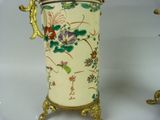 a vase that has a handle on it with flowers on it