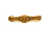 an image of a gold tie bar with a picture of a man on it