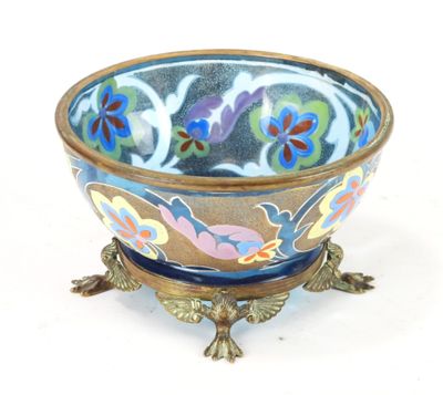 un bol bleu orné de fleurs, posé sur un socle