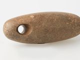 un caillou percé d'un trou sur une surface blanche