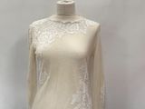 white lace top on a mannequin stand against a white backdrop