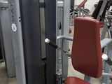 a gym machine with a red seat in the middle of the room
