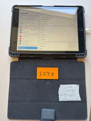 a tablet computer sitting on top of a desk with a notepad