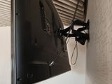 a flat screen tv mounted on the wall above a red chair