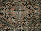 un tapis persan ancien, au motif complexe sur fond noir