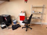 a desk with a chair and a book shelf in the corner