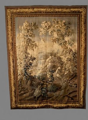 an antique tapestry hanging on a wall with a painting of a landscape