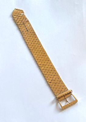 un gros plan d'un bracelet de montre sur une surface blanche