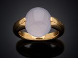 a gold ring with a white jade stone in the center