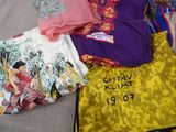 a pile of clothing on a bed with a name on it