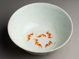 a white bowl with orange fish in it on a table