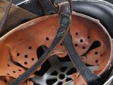 a helmet with a leather strap hanging from it ' s side