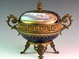 a blue and gold bowl with a lid on a stand