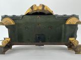 a green box with a gold decoration on it