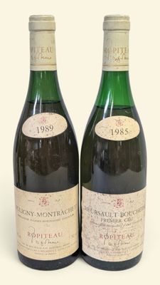 deux bouteilles de vin posées l'une à côté de l'autre sur une surface blanche