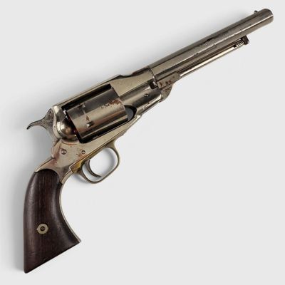 un vieux revolver avec un manche en bois sur fond blanc