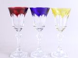 trois verres à vin de couleurs différentes posés les uns à côté des autres sur une surface blanche
