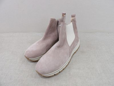 pink sued ankle boots with white soles on a white surface