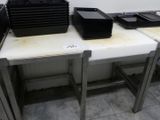 Plusieurs plateaux de nourriture sont posés sur une table dans une cuisine.