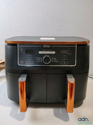 une friteuse à air chaud noire et orange posée sur un plan de travail