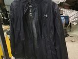une veste noire suspendue à un portant dans un garage
