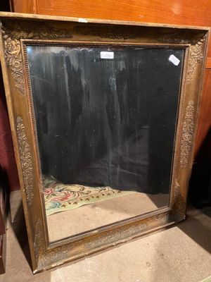 a mirror that is sitting on the floor next to a chair