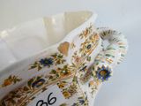 a white vase with a floral design on it