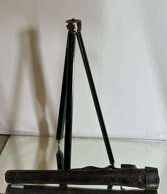 an old camera on a tripod stand on a glass table