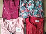 quatre t-shirts pour femmes posés sur une boîte en carton avec une étiquette de prix