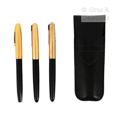 un lot composé de trois stylos noirs et dorés et d'un étui