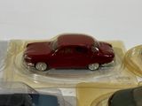 a red toy car sitting on top of a table next to other toy cars