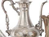 une cafetière en argent posée à côté d'un pichet en argent