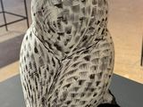 sculpture of a white owl on a black table in a room