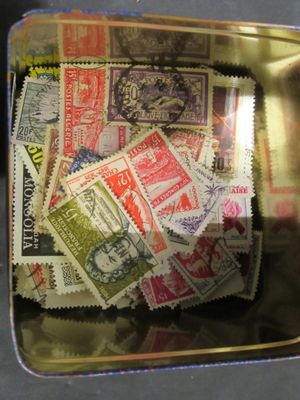 de nombreux timbres différents dans une boîte en métal posée sur une table