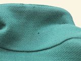 a close up of a green shirt with a small hole in the middle of it