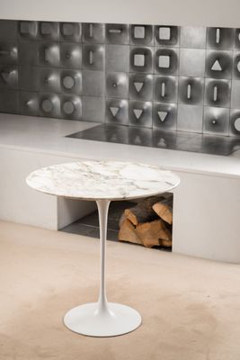 une table blanche avec un plateau en marbre dans une pièce