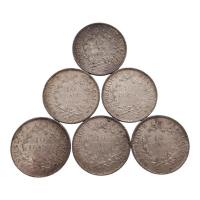 six pièces d'argent disposées en pyramide sur un fond blanc