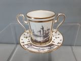 une tasse et une soucoupe ornées d'une illustration représentant un château
