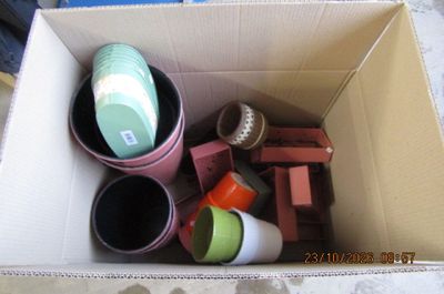 une boîte en carton remplie d'objets hétéroclites sur le sol
