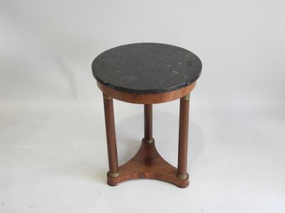 une table avec un plateau en marbre noir, des pieds en bois et un piètement en bois