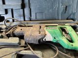 a green and black corded drill and a tool in a case