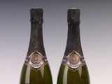 two bottles of champagne sitting next to each other on a table