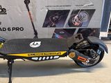a black and yellow scooter with a box in the background