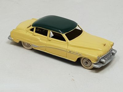 yellow toy car with a green roof on a white surface
