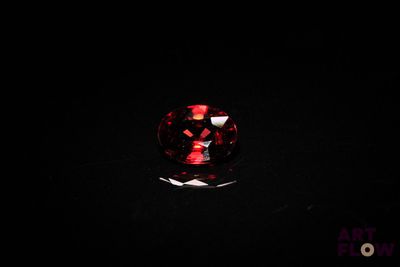 a close up of a red diamond on a black surface