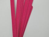 pink nail files are being held by a person ' s hand on a white surface