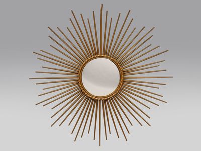 un miroir doré à rayons, accroché au mur