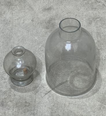 a glass vase and a glass jar sitting on the floor