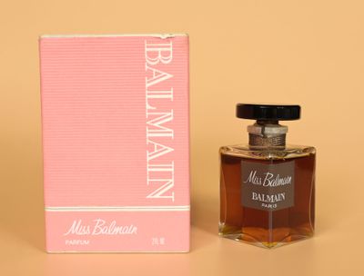 the bottle of perfume is next to the box on the table