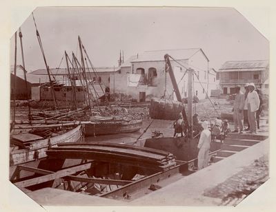 people standing on a dock next to boats in the water